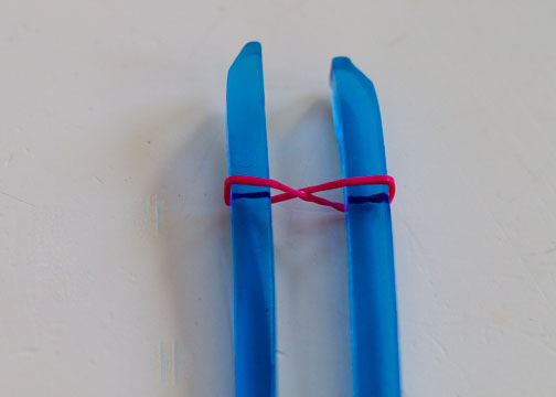 STEP 1: Slip a band around one chopstick, twist it, and slip the resulting loop over the second band. This is the only step that includes a twist.
